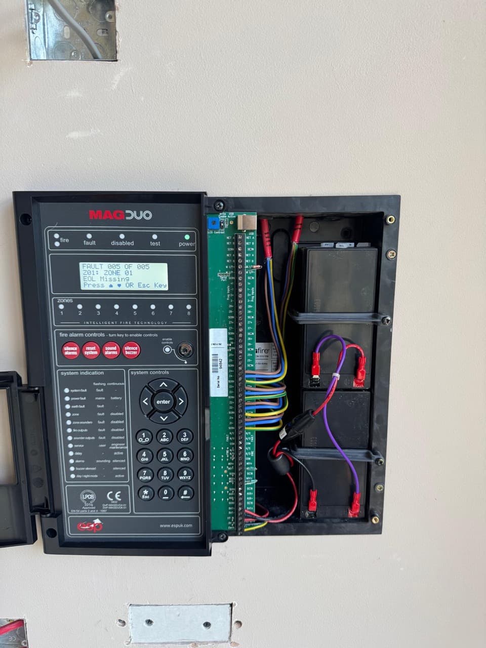 MAGDUO fire alarm control panel open showing the zone wiring and battery backup
