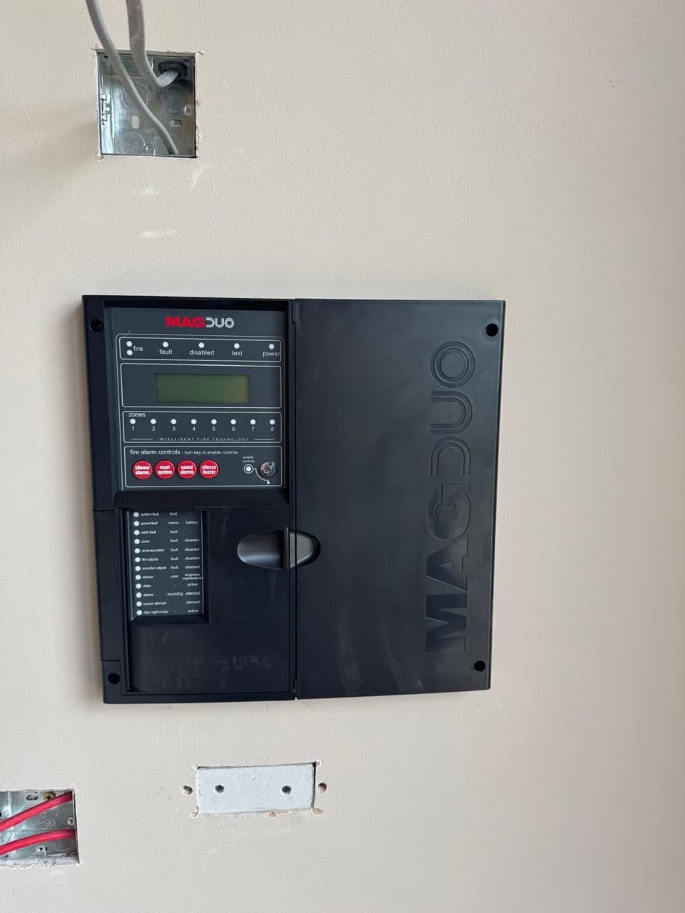 Wall-mounted MAGDUO addressable fire alarm control panel installed in a commercial unit